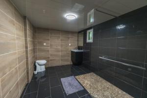 a tiled bathroom with a toilet and a sink at Suite Tentation avec Jacuzzi in Châteauneuf-lès-Martigues
