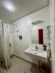 a white bathroom with a sink and a mirror at Hôtel LAKASBAH Ait Ben Haddou in Aït Benhaddou