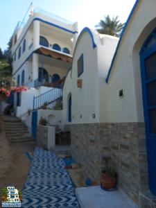 a house with blue and white walls and a building at Nubian Lotus in Aswan