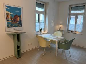a dining room with a white table and chairs at Schmuckstück an der Wormser Stadtmauer in Worms