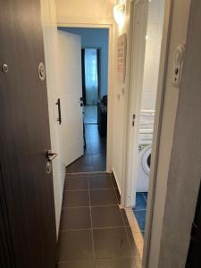 un corridoio con porta aperta su un bagno di Alex Apartment a Balş