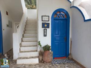 una puerta azul en un edificio blanco con escaleras en Nubian Lotus, en Asuán