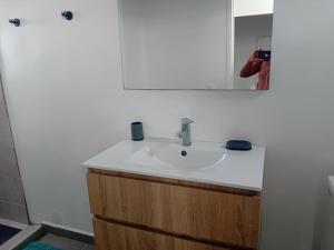 a person taking a picture of a bathroom sink at sci careffour dugomier in Le Moule