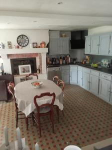 a kitchen with a table and chairs and a fireplace at Les Hirondelles in Saint-Georges-sur-Layon +3 photos