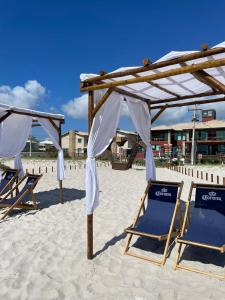 duas cadeiras de praia sob um toldo na praia em Pier Beach Club em Škorak