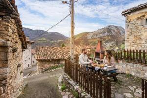 a man and woman sitting at a table on a balcony at Montegrande, entorno mágico rodeado de montañas in La Plaza