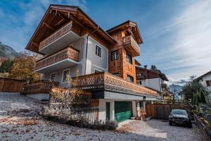 a house with wooden balconies and a car parked in front at Villa Eisl-Raudaschl in St. Wolfgang