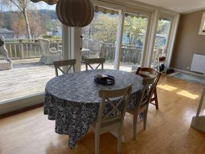 Kungsbacka Företagsbostad في كونغْسباكا: غرفة طعام مع طاولة وكراسي وشرفة +صورة واحدة