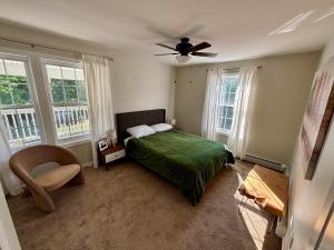 Un dormitorio con una cama y un ventilador de techo. en Designer home sleeps 10 winter water views, en South Portland