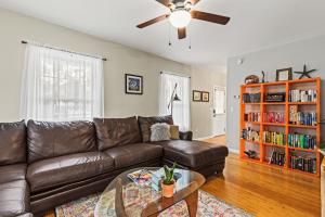 sala de estar con sofá de cuero marrón y estantería de libros en Designer home sleeps 10 winter water views, en South Portland