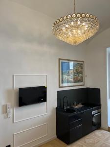 a bathroom with a black sink and a chandelier at Fiorentine Relais in Naples