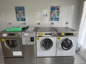 Drei Waschmaschinen befinden sich in einer Waschküche in der Unterkunft Grand Panorama in Saint-Gervais-les-Bains
