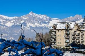 ein Gebäude mit einem schneebedeckten Berg im Hintergrund in der Unterkunft Grand Panorama in Saint-Gervais-les-Bains