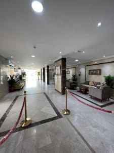 a lobby with couches and a red rope in a building at شقق العرين للشقق المخدومة in Jeddah
