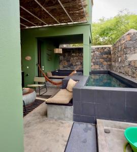 a hot tub in a house with a patio at Casa Archipel - Lagedos in Ribeira Fria