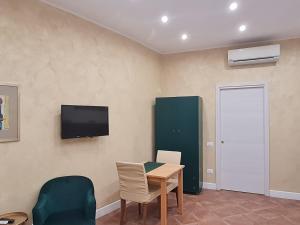 a room with a table and chairs and a television at Eden House in Crotone