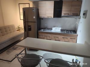 uma pequena cozinha com uma mesa e uma geladeira em Consentir apto 2 alcobas em Pereira