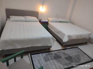 Duas camas num pequeno quarto com um tapete em Consentir apto 2 alcobas em Pereira