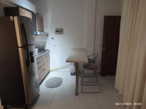 uma cozinha com uma pequena mesa e um frigorífico em Consentir apto 2 alcobas em Pereira