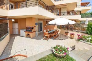 a patio with a table and an umbrella at Nerida House Salonikiou Beach in Akti Salonikiou