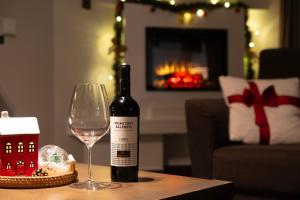 a bottle of wine and a wine glass on a table at Lipno Stories in Lipno nad Vltavou