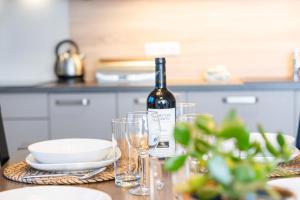 a bottle of wine sitting on a table with glasses at Lipno Stories in Lipno nad Vltavou +22 photos