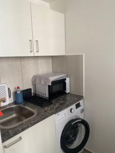 a kitchen with a washing machine and a microwave at New komplett möblierte Wohnung-Zentral in Sindelfingen
