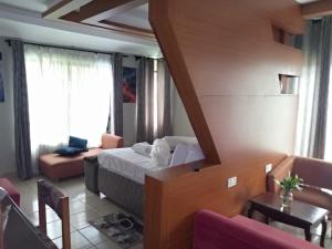 布科巴WalkGard WestLand HOTEl的一间带床的卧室和一间带沙发的客厅