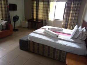 布科巴WalkGard WestLand HOTEl的一间卧室，床上有一张带毛巾的床