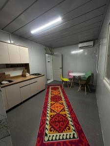 una cocina con alfombra en el medio de una habitación en Nomad Kyrgyz Hostel, en Bishkek