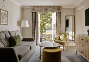 a living room with a couch and a table at Horwood House Hotel in Milton Keynes