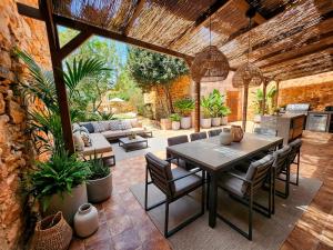 een terras met een tafel, stoelen en een bank bij Casa Ca'n Bernat in Santanyi