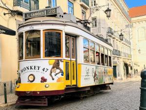 a yellow and white trolley on a city street at Solar dos Poetas in Lisbon +18 photos