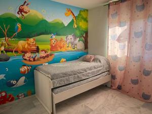 een kinderkamer met een cartoonmuurschildering op de muur bij Casa Familiar Atarfe in Atarfe