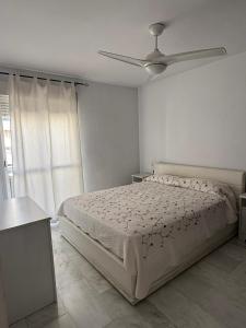 een slaapkamer met een bed en een plafondventilator bij Casa Familiar Atarfe in Atarfe