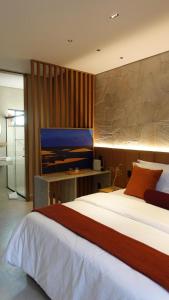 um quarto com uma cama grande e uma televisão em Be Caju Hotel em Barra Grande