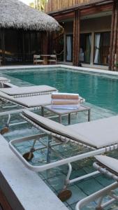 a swimming pool with lounge chairs in the water at Be Caju Hotel in Barra Grande