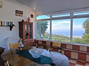 埃尔帕索Bungalow Los Guanches 3的带桌子和大窗户的餐厅