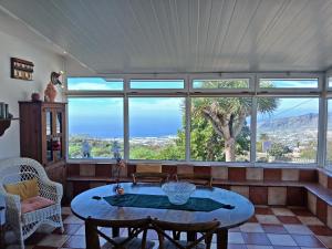 埃尔帕索Bungalow Los Guanches 3的客厅里有一张桌子和一扇大窗户。
