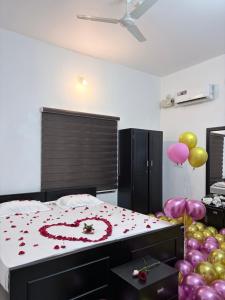 a bedroom with a bed with a heart made out of roses at Seawind in Kannur +49 photos