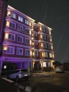 a purple building with a car parked in front of it at Apartment with FREE Massage chair Fergana in Fergana