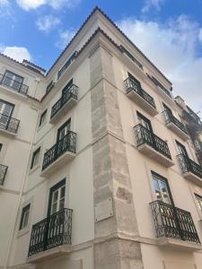 a tall white building with balconies at Rossio Garden Suites in Lisbon
