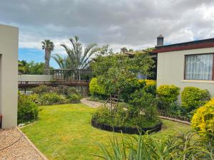 a garden with plants and a house at Princess Holiday Home in Cape Town
