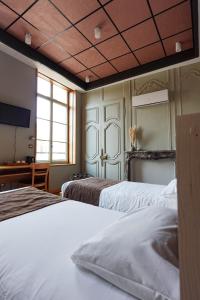 a hotel room with two beds and a tv at Hôtel - Restaurant Au Tonnelier in Bergues +88 photos