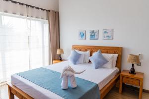a stuffed animal is sitting on a bed at Summer Palms Villa in Flic-en-Flac +46 photos