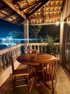 a wooden table and chairs on a balcony at Casa Maria Areia Boutique in Camocim