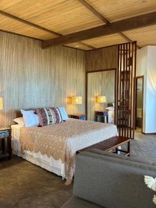 a bedroom with a bed and a couch at Casa Maria Areia Boutique in Camocim