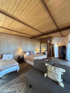 a living room with two beds and a couch at Casa Maria Areia Boutique in Camocim