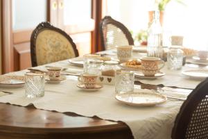 Room & Breakfast La Dimora في سولمونا: طاولة عليها صحون واكواب +29 صورة