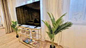 a living room with a couch and a table with plants at Orientarium Atlas Arena Family House in Łódź